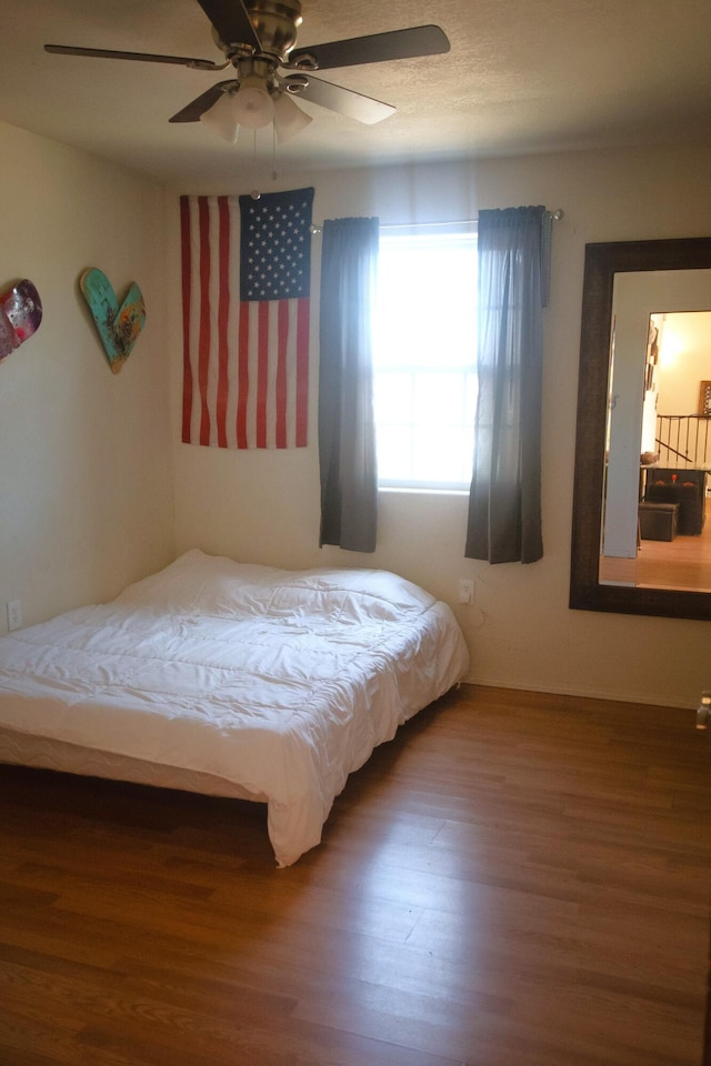 bedroom featuring a ceiling fan and wood finished floors