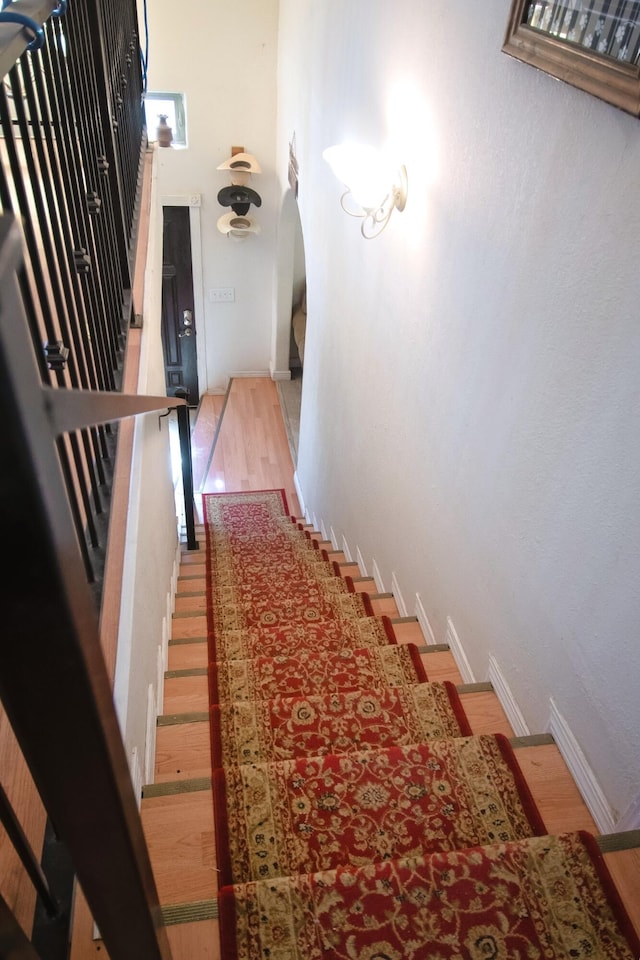 staircase with wood finished floors and baseboards