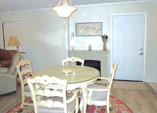 dining space featuring wood finished floors, baseboards, and ornamental molding