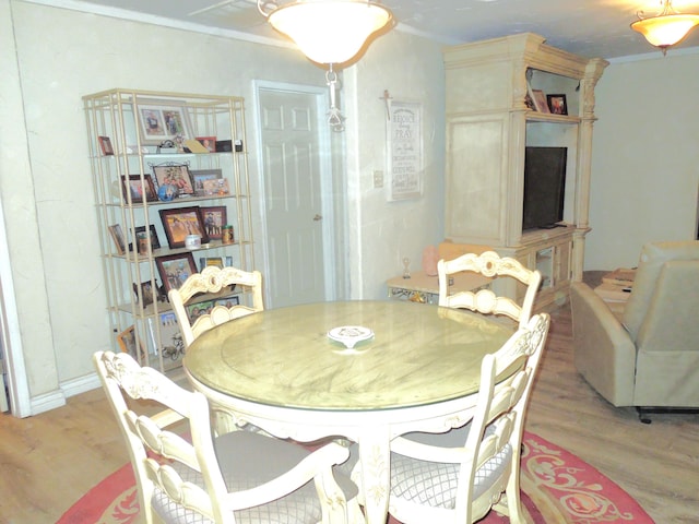 dining space featuring crown molding and wood finished floors