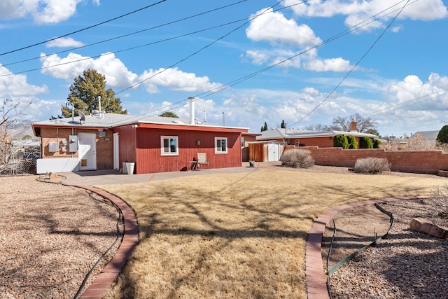 back of property featuring fence and a lawn