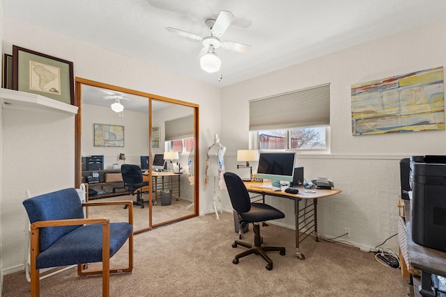 carpeted office space featuring a ceiling fan