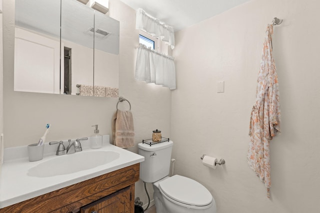 bathroom with visible vents, toilet, and vanity