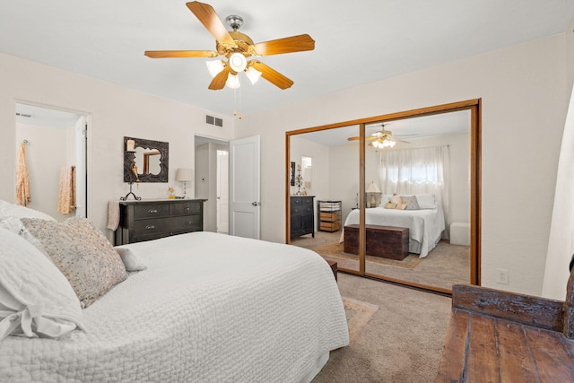 carpeted bedroom featuring a closet, visible vents, and a ceiling fan