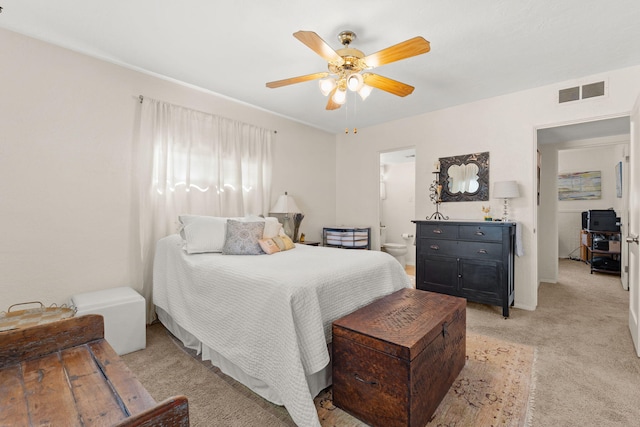 bedroom featuring visible vents, light carpet, a ceiling fan, and ensuite bathroom