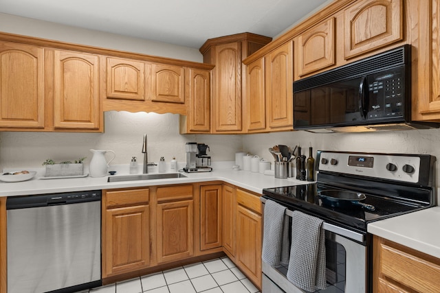 kitchen with light countertops, light tile patterned floors, appliances with stainless steel finishes, and a sink