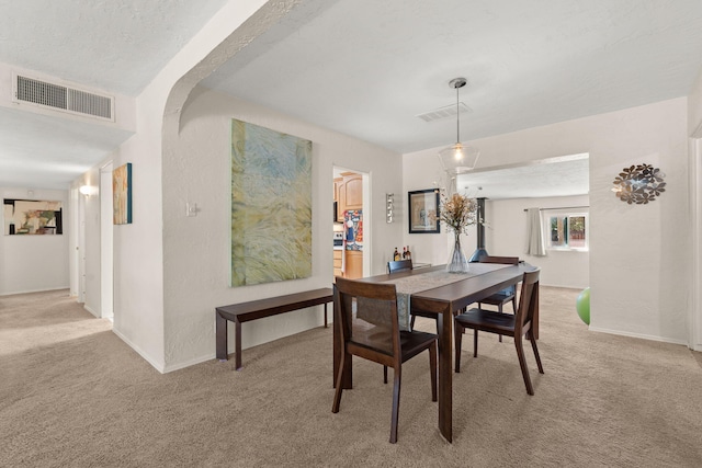 dining area with light carpet, visible vents, and baseboards