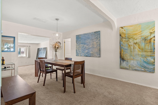 carpeted dining space with visible vents and baseboards