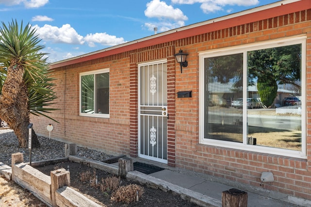 view of exterior entry with brick siding