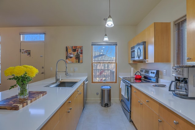 kitchen with light countertops, light tile patterned flooring, appliances with stainless steel finishes, and a sink