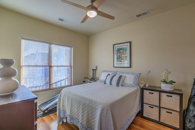 bedroom featuring wood finished floors, visible vents, and ceiling fan