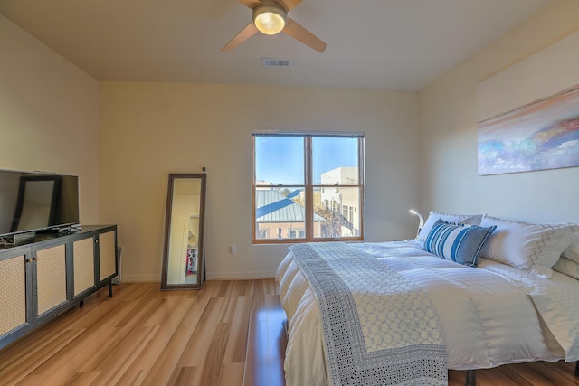 bedroom with visible vents, baseboards, light wood-style floors, and ceiling fan