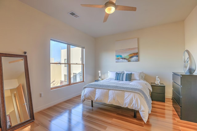 bedroom featuring ceiling fan, baseboards, visible vents, and light wood-type flooring