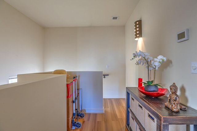 hallway with visible vents and light wood finished floors