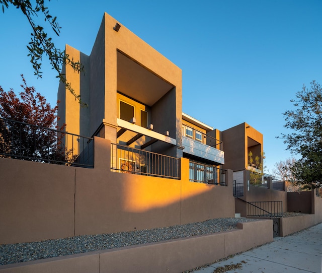 view of front of home with fence and stucco siding