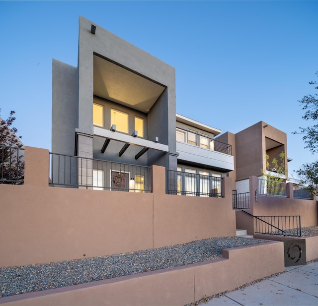 view of side of property featuring stucco siding and fence