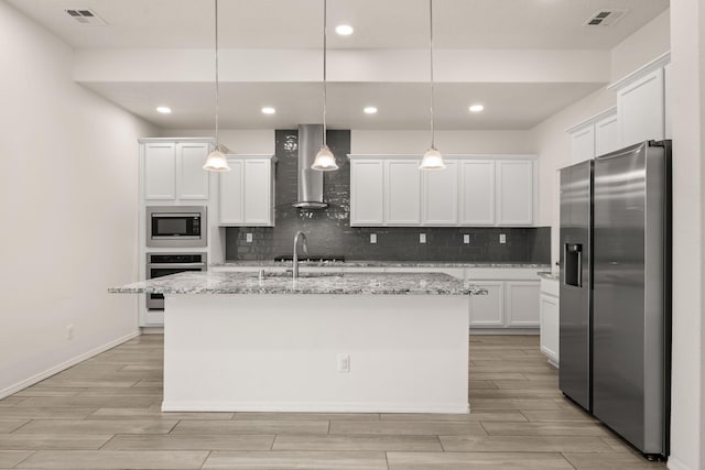 kitchen featuring stainless steel appliances, visible vents, wood tiled floor, and wall chimney range hood