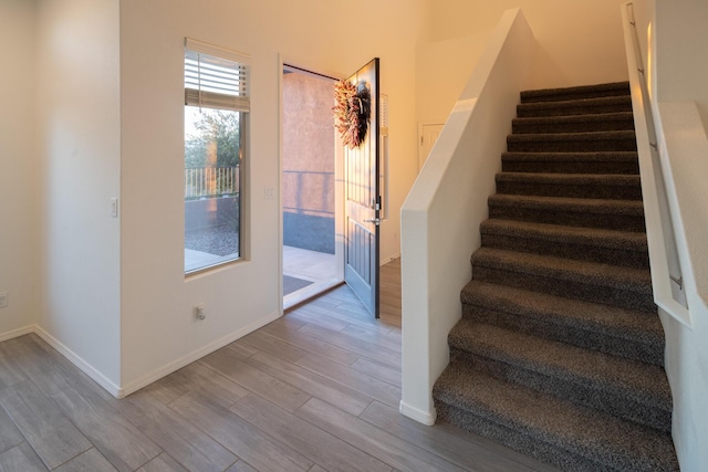 stairs featuring wood finished floors and baseboards