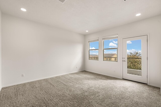 carpeted empty room featuring baseboards, recessed lighting, and a textured ceiling