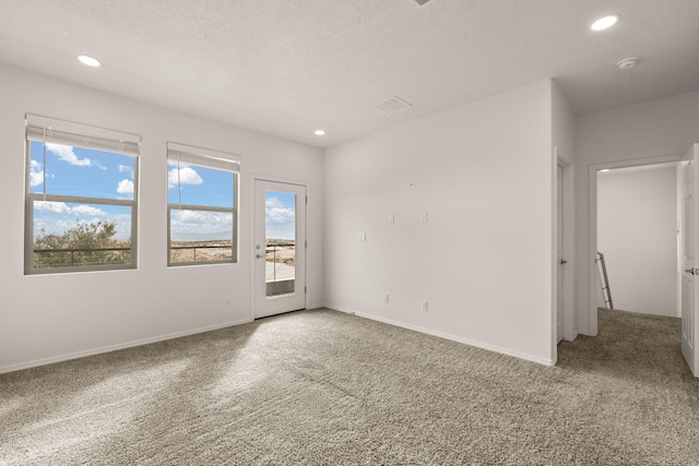 carpeted spare room featuring recessed lighting, a textured ceiling, and baseboards