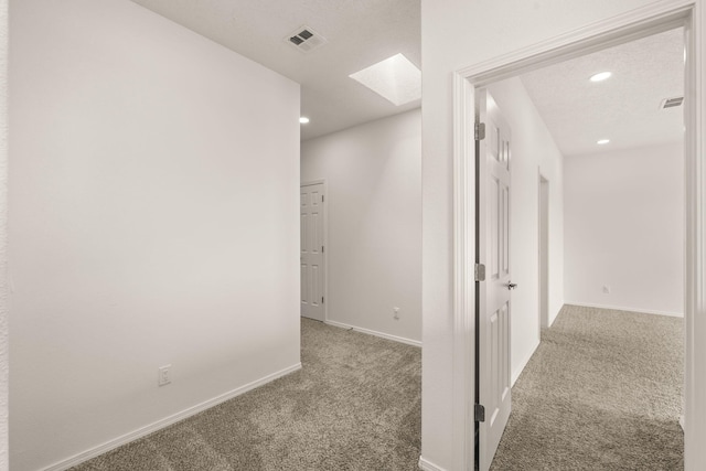 hallway with recessed lighting, carpet flooring, visible vents, and a skylight