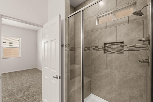 bathroom with a shower stall and baseboards