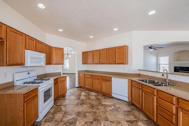 kitchen with ceiling fan, white appliances, a wealth of natural light, and a sink