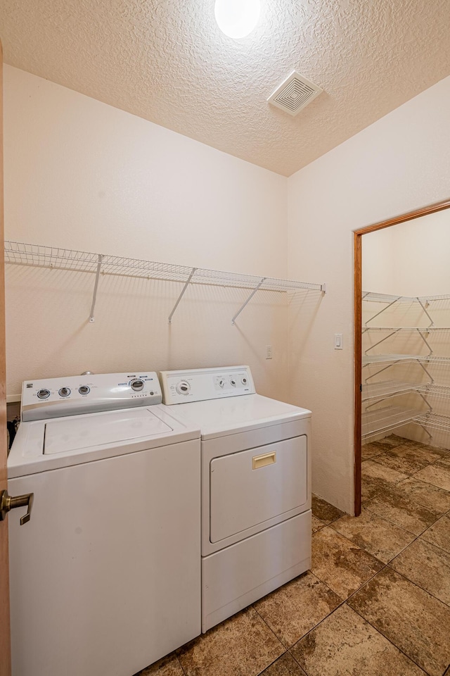 laundry area featuring washer and dryer, laundry area, visible vents, and a textured ceiling