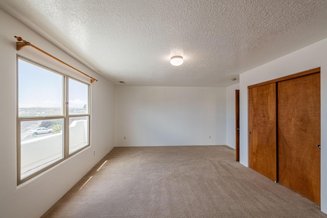 unfurnished bedroom with a closet, carpet floors, and a textured ceiling