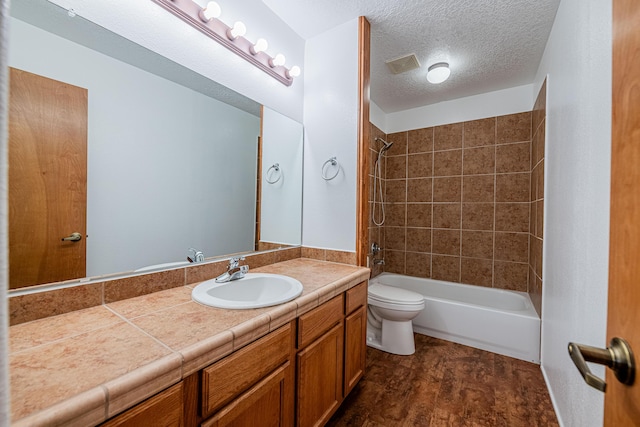 bathroom with toilet, vanity, wood finished floors, a textured ceiling, and  shower combination