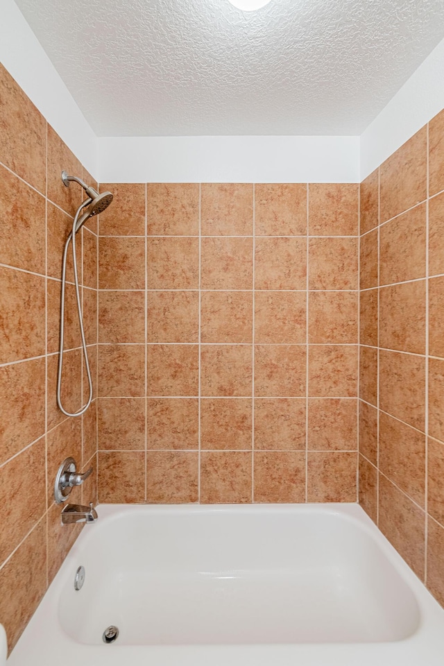 full bath featuring shower / bathing tub combination and a textured ceiling