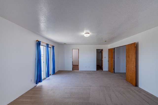 interior space with a textured ceiling and carpet flooring