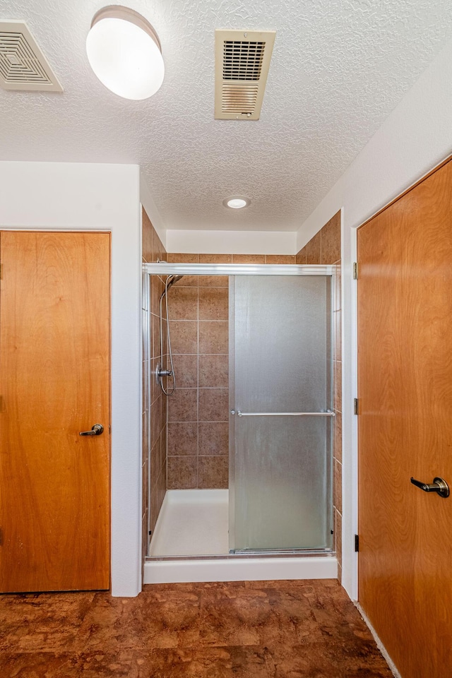 bathroom with visible vents and a shower stall