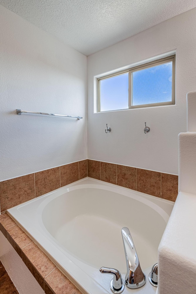 bathroom featuring a textured ceiling and a garden tub