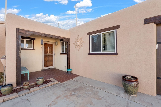 property entrance featuring a patio area and stucco siding