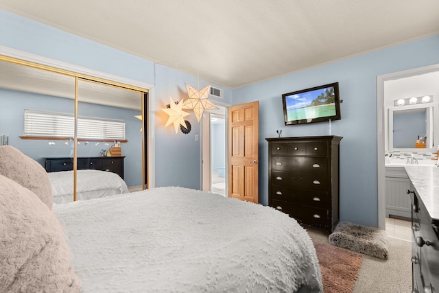 carpeted bedroom featuring visible vents, a closet, and connected bathroom