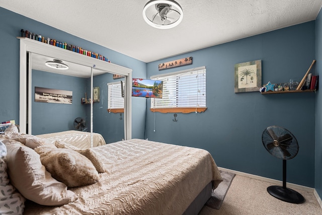 carpeted bedroom featuring baseboards and a textured ceiling