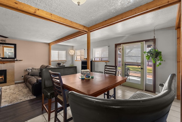 dining space featuring an ornate ceiling, a fireplace, baseboards, and a wealth of natural light