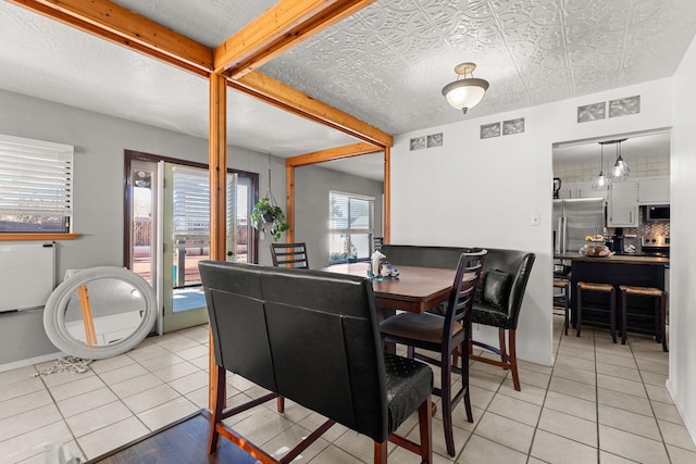 dining space with light tile patterned flooring, visible vents, and baseboards