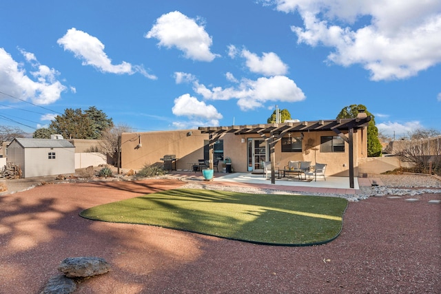 rear view of house with a patio, an outbuilding, a pergola, stucco siding, and an outdoor hangout area