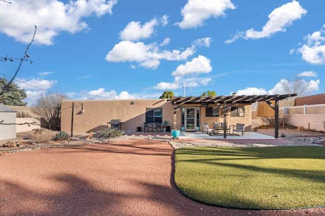 back of property with a patio area, stucco siding, a pergola, and fence