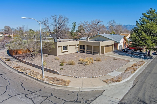 view of front facade featuring a garage, driveway, and stucco siding