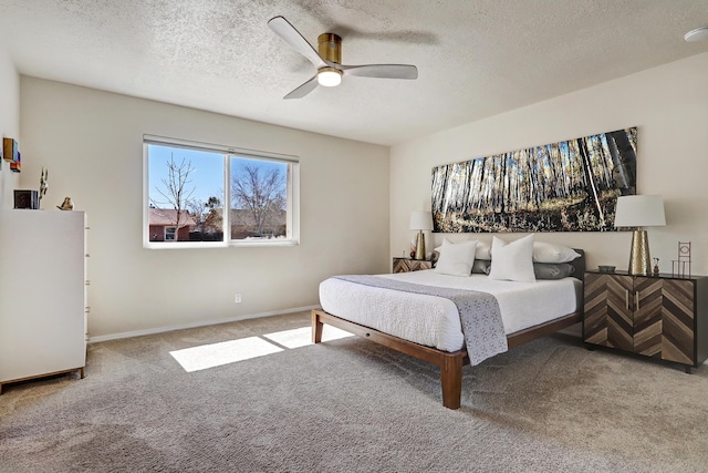 bedroom with carpet flooring, a ceiling fan, baseboards, and a textured ceiling