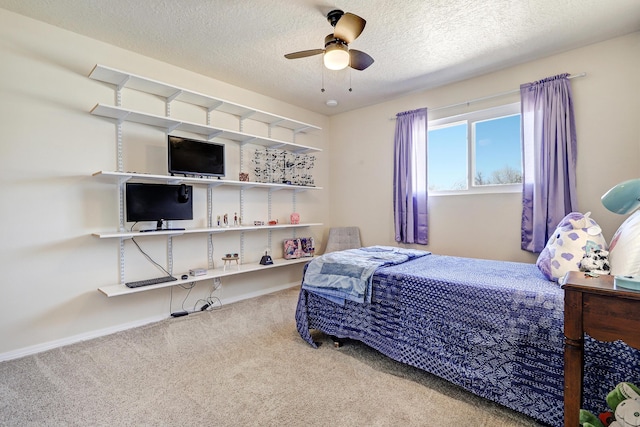 carpeted bedroom with ceiling fan, baseboards, and a textured ceiling