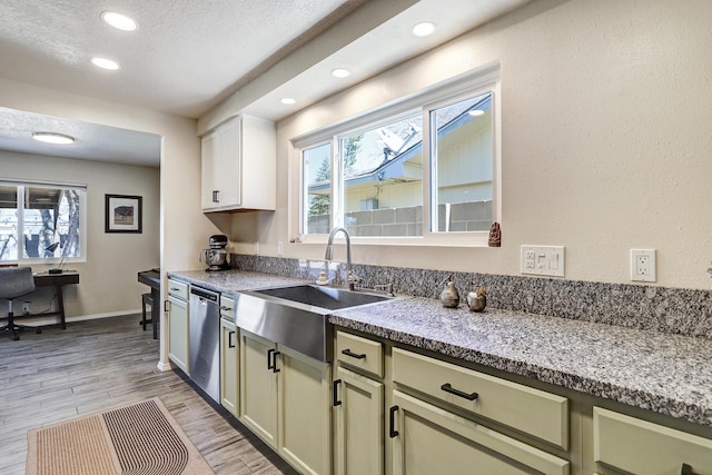 kitchen with stainless steel dishwasher, a healthy amount of sunlight, light wood-type flooring, and a sink