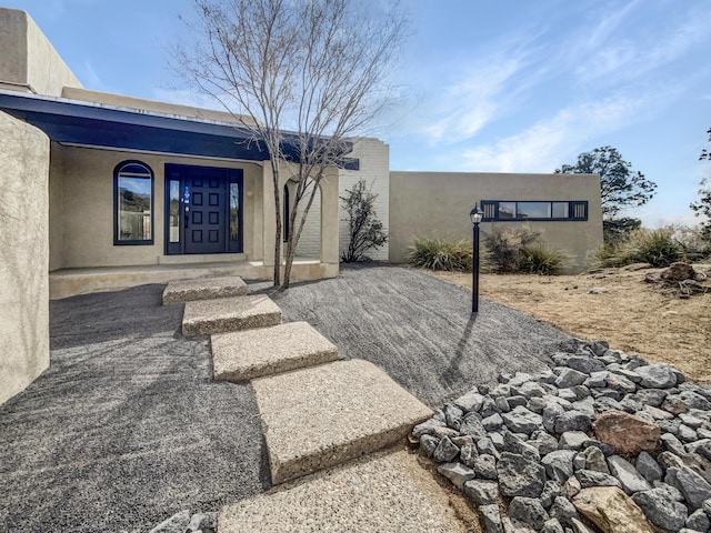 doorway to property featuring stucco siding