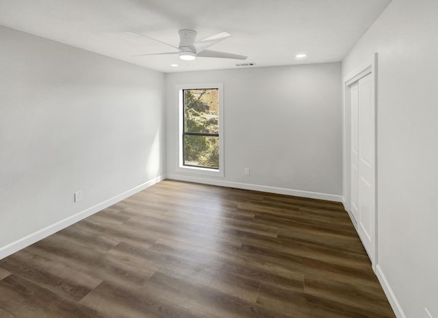 spare room featuring a ceiling fan, dark wood-style floors, visible vents, baseboards, and recessed lighting