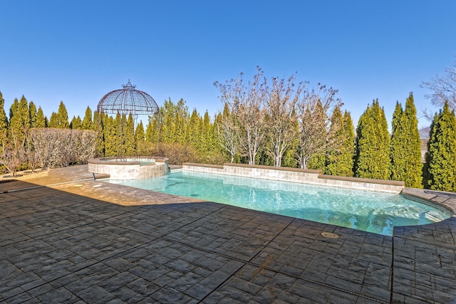 view of pool featuring a pool with connected hot tub and a patio