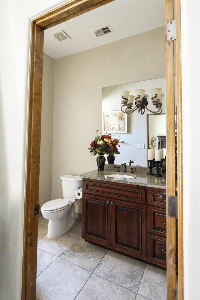 bathroom featuring a notable chandelier, visible vents, toilet, and vanity