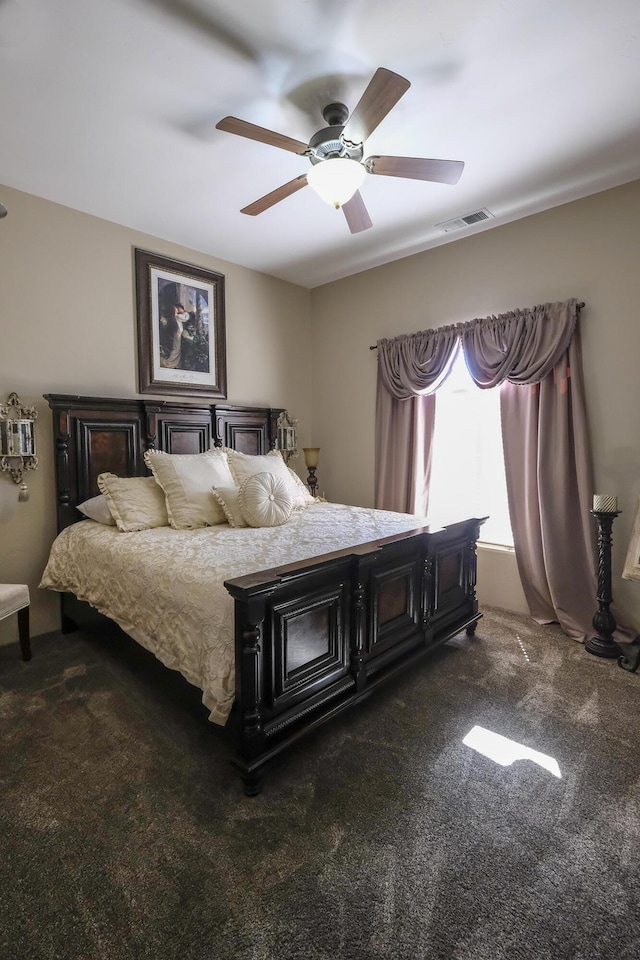 bedroom featuring visible vents, a ceiling fan, and dark carpet